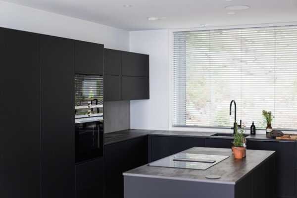Keraamiset tasot tuovat eloa mustaan keittiökokonaisuuteen. Vetimettömyys sopii minimalistiseen tyyliin.