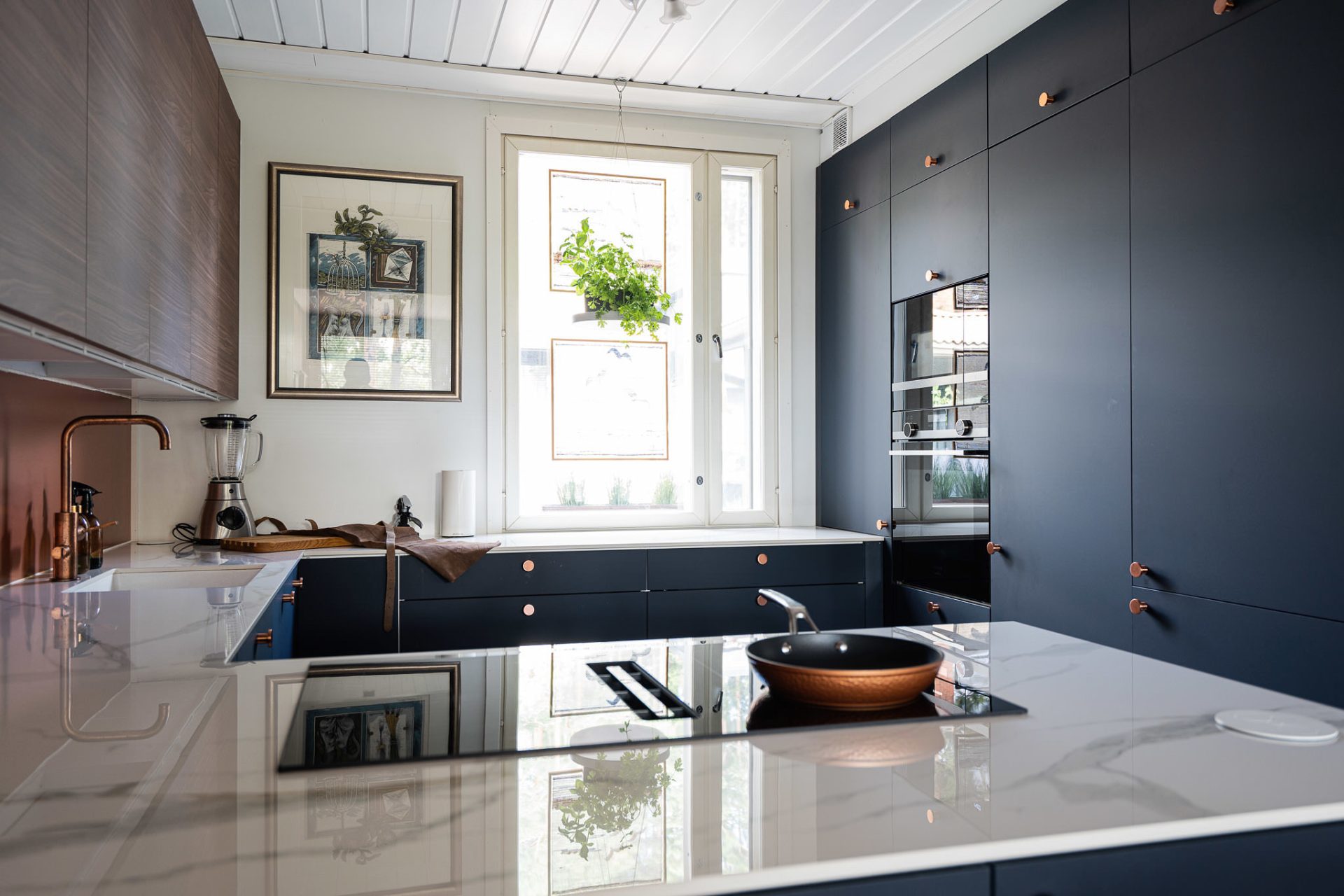 70-luvun kodin sinisen ja ruskean sävyinen Unique Home -keittiö ja keittotasoon integroitu liesituuletin.