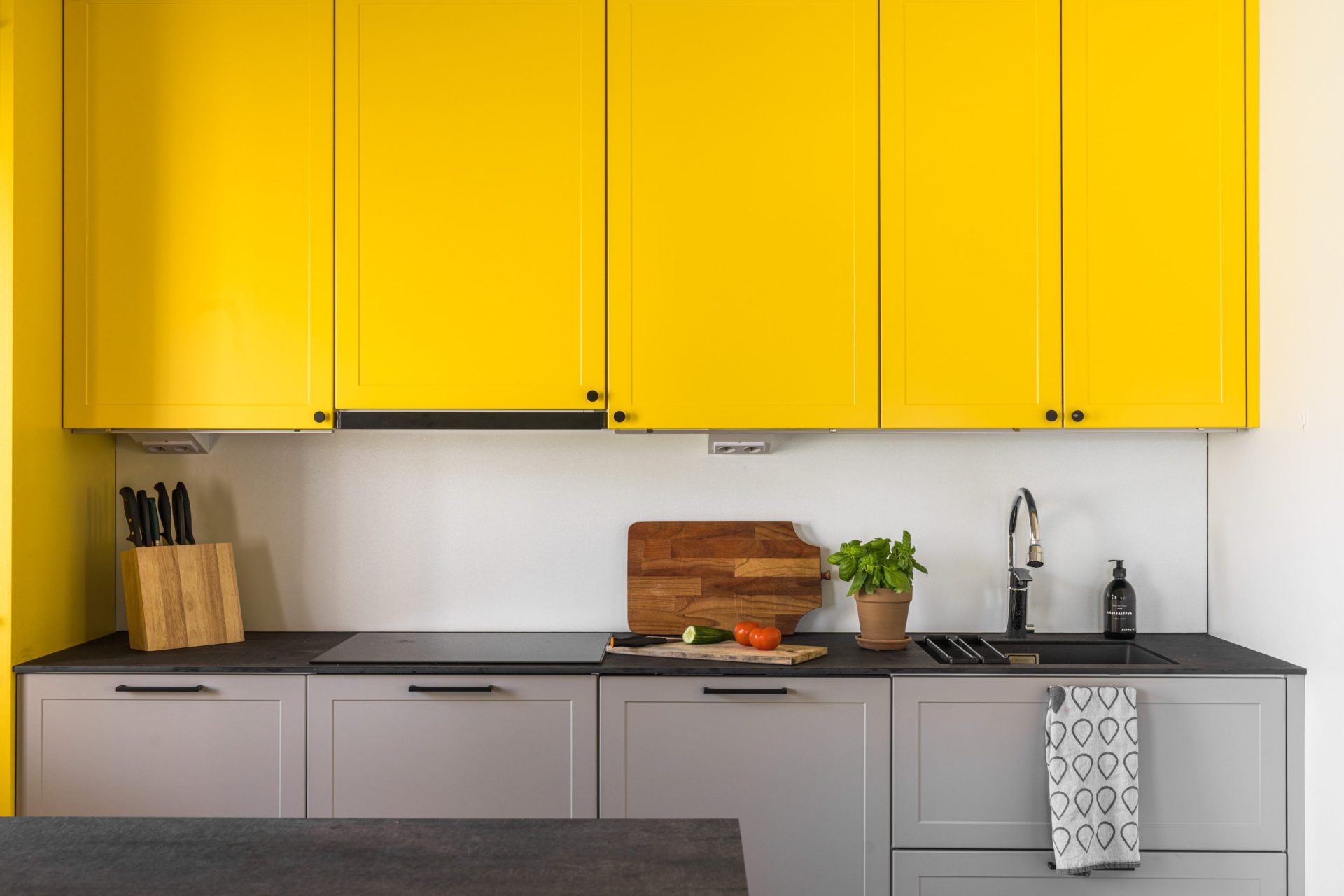 Tikkurilan värikartasta valittu keltainen ja harmaa yhdistyvät kaapistoissa.
