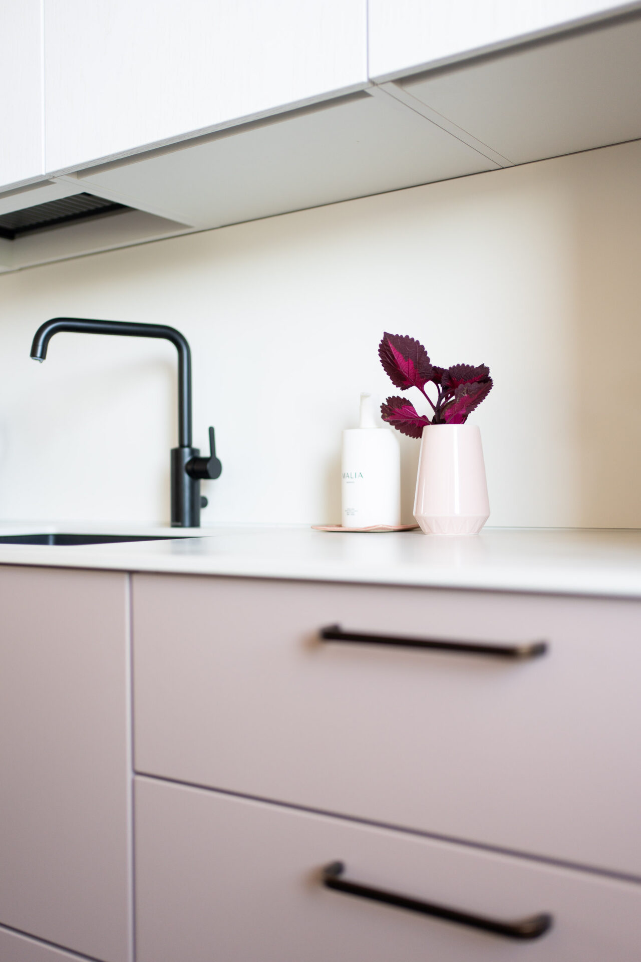 Vaaleanpunainen valloittaa keittiössä. Vedinmallina on Helatukun antiikkiruskea Alfa.