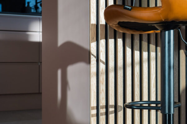 Roosa kaapistosävy, mustat tehosteet sekä puurimoitus toimivat yhteen tässä keittiökokonaisuudessa.