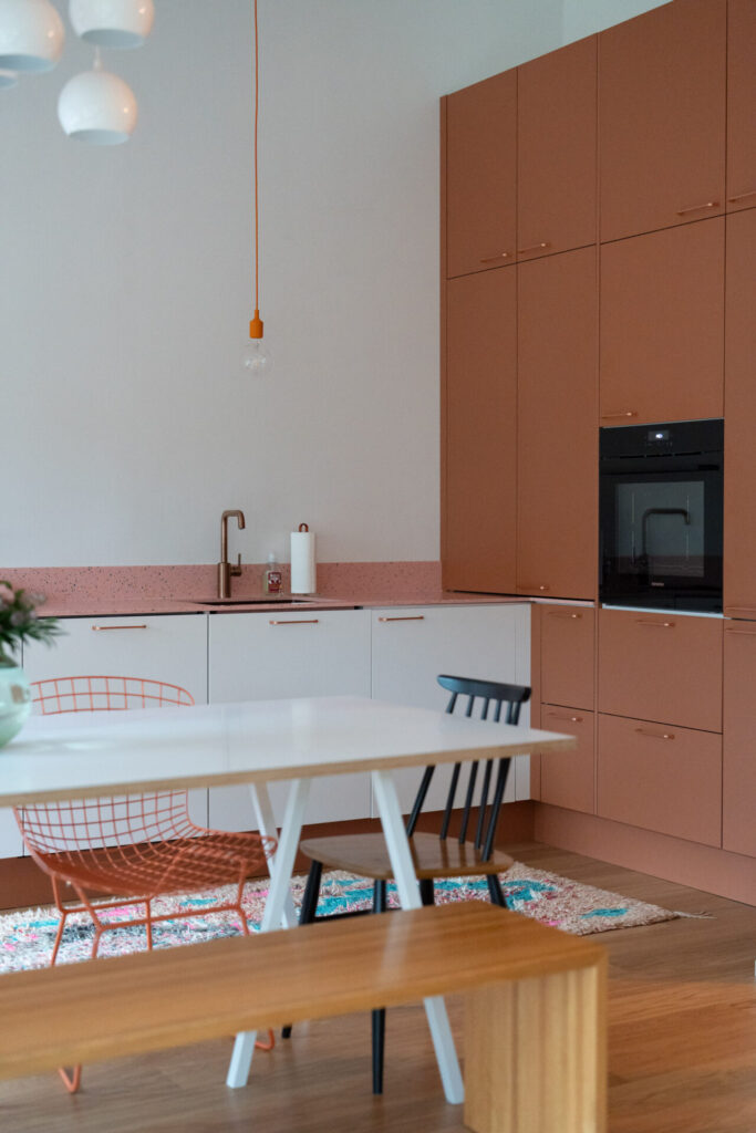 Poltetun oranssit kaapistot ja monivärinen Durat-taso tuovat iloa ja leikkisyyttä keittiöön.