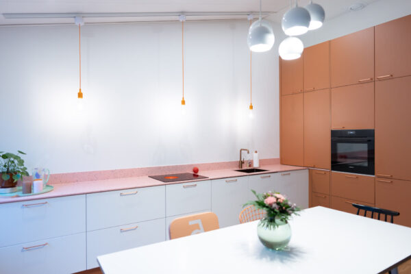 Murretun oranssi komeroseinä Allasseinän valkoiset kaapistot rauhoittavat muuten värikästä kalustekokonaisuutta.