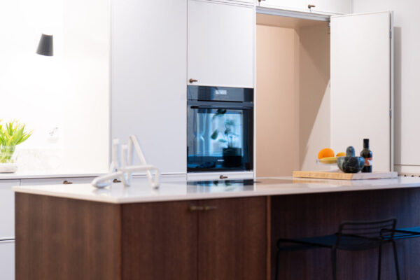 Kaksivärisessä keittiössä ruokakomeron kulkuovi naamioituu komeroseinään.