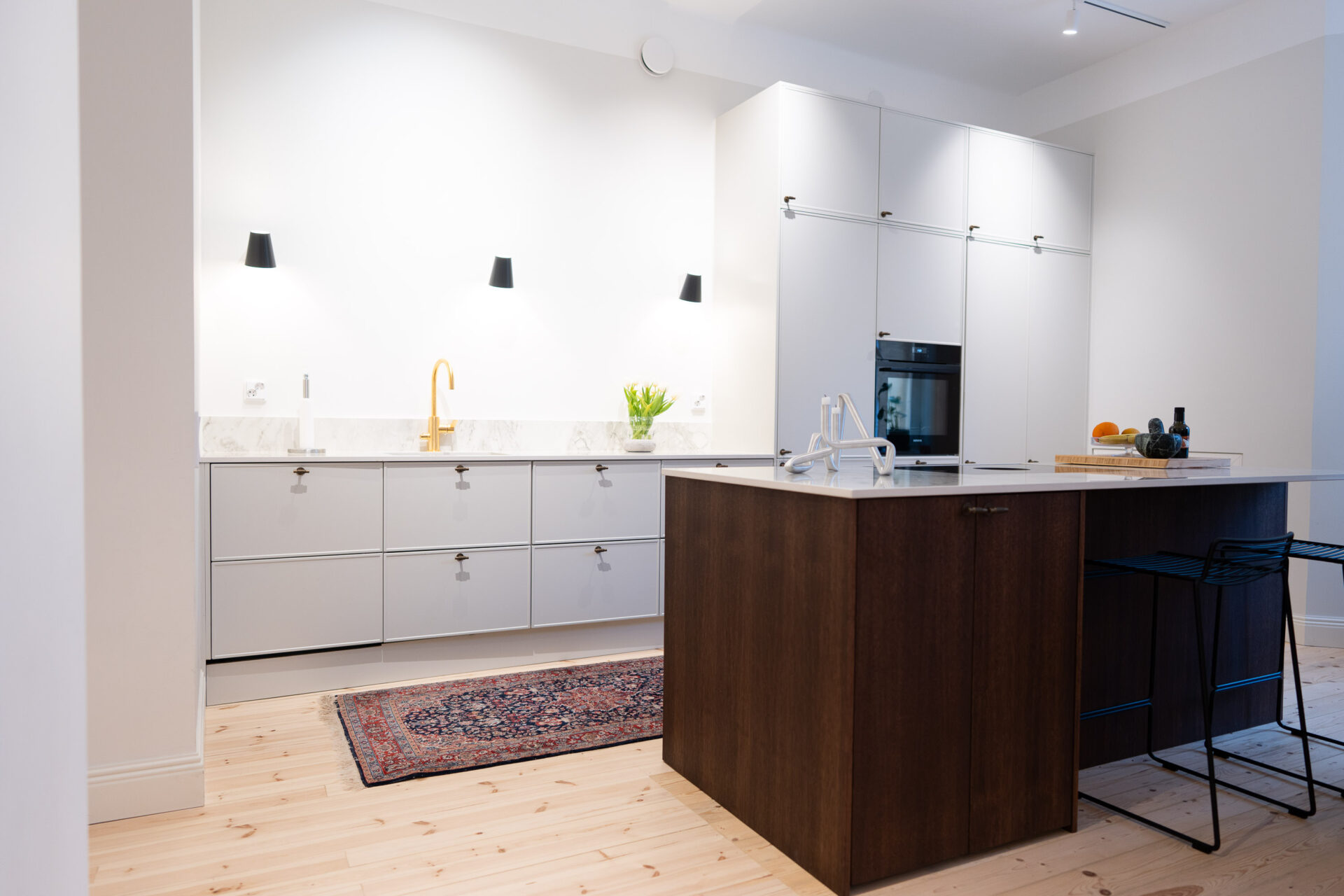 Kaksivärinen keittiö yhdistelee suklaiseksi sävytettyä tammiviilua sekä Tikkurilan Piazzaa maalatuissa ovissa.