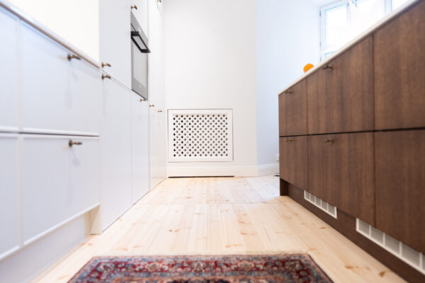 Kaksivärinen keittiötoteutus yhdistelee maalattuja mdf-ovia sekä oman tuotantomme tammiviilua ruskealla sävytyksellä.