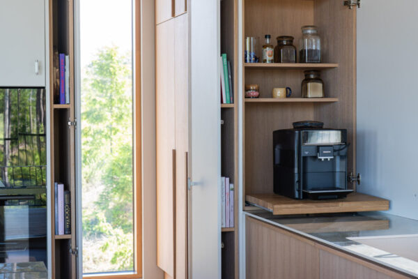 Pantryovet avautuvat komeroon päin ja paljastavat samalla saranoiden viereen jäävät kapeat hyllyköt, jotka ovat omiaan esimerkiksi ruokakirjoille.